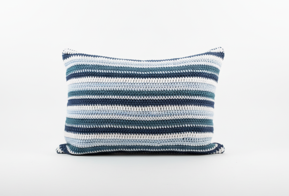 Blue and white striped crochet cushion on a white background