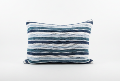 Blue and white striped crochet cushion on a white background