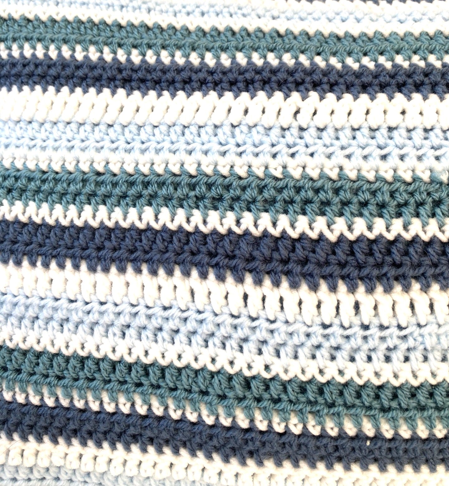 Close-up of just cushions  crocheted cushion with blue and white stripes.