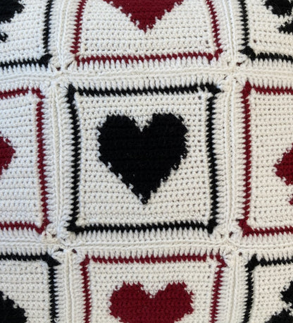 just cushions close up of crochet cushion with a black red and white playing cards pattern