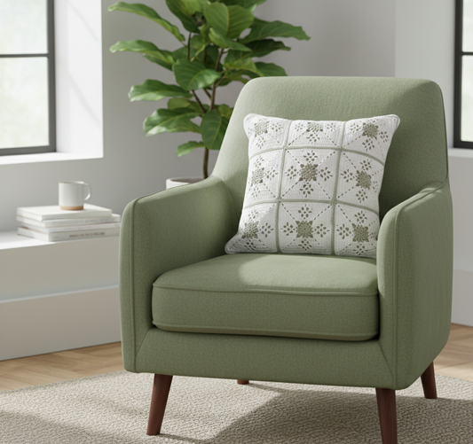 Green armchair with a decorative crochet cushion in green and white featuring a victorian lace pattern