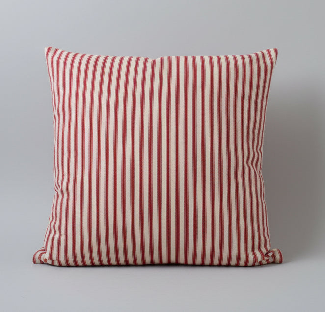 Red and cream striped ticking cushion on a gray background