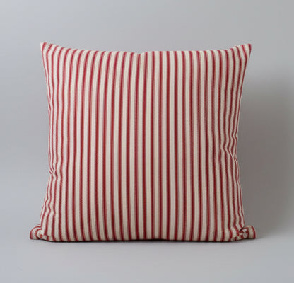 Red and cream striped ticking cushion on a gray background